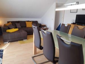 a living room with a couch and a table with chairs at Feriendorf Schwarzholz in Viechtach +287 photos