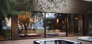 a building with a large window with a hot tub at Hotel Baia Azzurra - Lake Front in Nago-Torbole