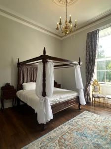 a bedroom with a canopy bed and a chandelier at Uppercourt Manor in Freshford