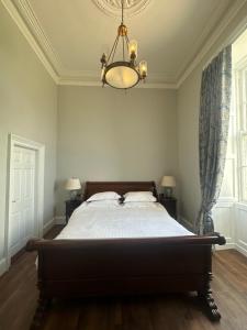 a bedroom with a large bed with a chandelier at Uppercourt Manor in Freshford
