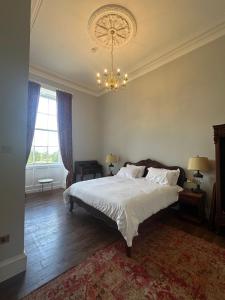 a bedroom with a large bed and a chandelier at Uppercourt Manor in Freshford