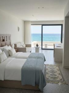 a bedroom with a bed and a view of the ocean at Tinos Beach Hotel in Kionia +89 photos