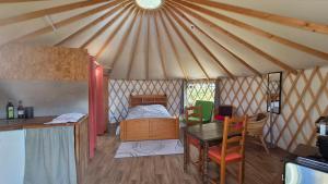 a room with a bed and a table in a yurt at Yourtes insolites in Querrien