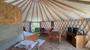 a room with a tent with a table and a microwave at Yourtes insolites in Querrien