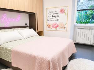 a bedroom with a bed with a pink blanket at La Casetta in Genoa
