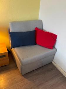 a couch with two red and blue pillows on it at FeWo Möwennest in Warnemünde