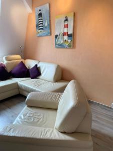 a living room with two white couches and a lighthouse at FeWo Möwennest in Warnemünde