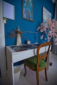 a desk in a room with a chair and a table at Chambre d'hôtes Bounty - terrasse, cuisine privée, garage in Olliergues