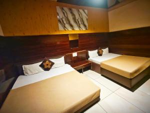 two beds in a room with two beds sidx sidx sidx at HOTEL OM PALACE NEAR MAHAKALESHWAR TEMPlE in Ujjain