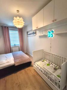 a bedroom with a baby crib and a room at Loft No 35 Premium Apartment in Głogów