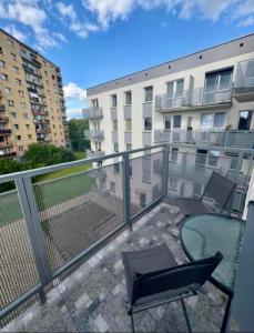 a balcony with a chair and a table and a building at Loft No 35 Premium Apartment in Głogów
