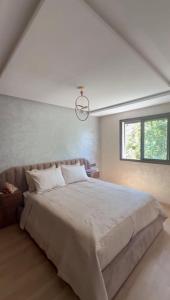 a bedroom with a large bed and a window at Appartement - centre ville Ifrane in Ifrane