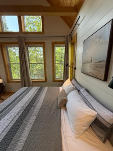 a bedroom with a large bed in a room with windows at Dock 124 - Adults Only, Waterfront B&B in Tobermory