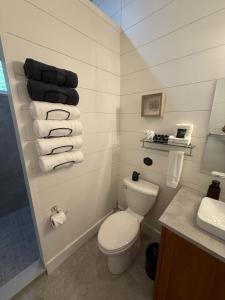 a bathroom with a toilet and a sink and towels at Dock 124 - Adults Only, Waterfront B&B in Tobermory
