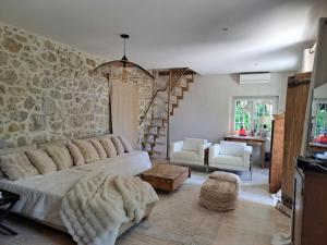 a living room with a couch and a stone wall at Bed and Breakfast with a View & Pool Bastide de Marie Grasse in Grasse