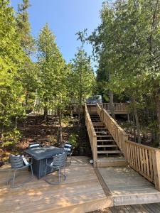 a wooden deck with a table and chairs and stairs at Dock 124 - Adults Only, Waterfront B&B in Tobermory