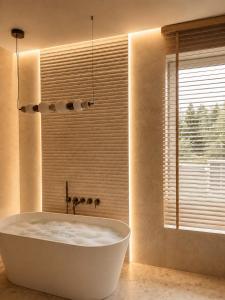 a bath tub in a bathroom with a window at oto harmonia in Rąbinek