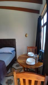 a room with a table and a bed and a table and chairs at El Nido in Samaipata