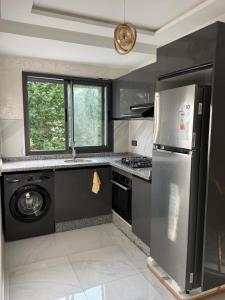 a kitchen with a stainless steel refrigerator and a dishwasher at Appartement - centre ville Ifrane in Ifrane