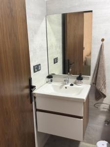 a bathroom with a white sink and a mirror at Appartement - centre ville Ifrane in Ifrane +9 photos