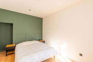 a bedroom with a white bed and a green wall at L'Aube des Alpes Hyper Centre Élégance et Confort in Thonon-les-Bains