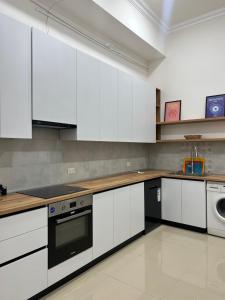 a kitchen with white cabinets and a dishwasher at Hostel Velvet Vouge in Yerevan