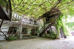an old building with stairs and ivy on it at Pensiune Taviada in Chişinău