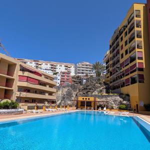 a large swimming pool in front of some buildings at CHC - Olivia Sunset II in Puerto de Santiago