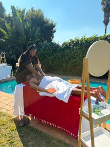 a woman standing over a man laying on a bed at Nikkita Wellness Spa in Pretoria