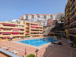 a swimming pool in front of some apartment buildings at CHC - Olivia Sunset II in Puerto de Santiago
