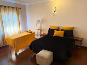 a bedroom with a black bed and a yellow blanket at Nikkita Wellness Spa in Pretoria +1 photo
