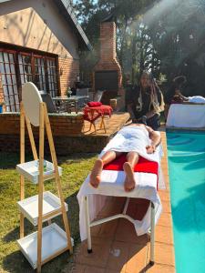 a woman laying on a bed next to a pool at Nikkita Wellness Spa in Pretoria