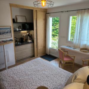 a bedroom with a bed and a desk and window at Chambre Studette indépendante in Briançon
