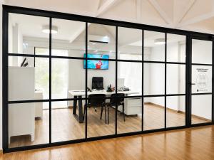 an office with glass walls and a desk at Luxmar Apartaments By MC in Benidorm