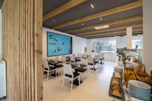 a restaurant with tables and chairs and a large screen at Oasis White Hotel in Sal Rei