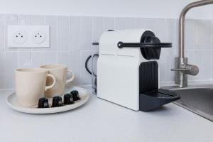 a coffee maker and two coffee cups on a kitchen counter at Le Cocon Perché - Centre Ville - Parking - Clim in Valence