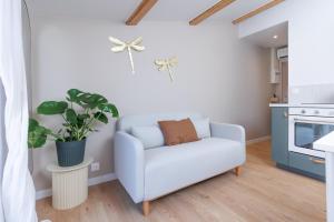 a living room with a white couch and a plant at Le Cocon Perché - Centre Ville - Parking - Clim in Valence +17 photos