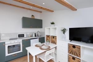a kitchen with a table and a tv on a wall at Le Cocon Perché - Centre Ville - Parking - Clim in Valence