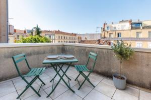 a table and two chairs on a balcony at Le Cocon Perché - Centre Ville - Parking - Clim in Valence