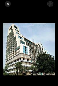 a large building with a tree in front of it at stay elan in Greater Noida