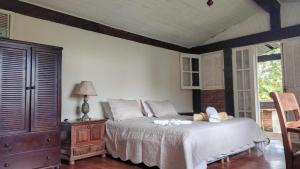 a bedroom with a bed and a table with a lamp at Fazenda Vista Soberba in Nova Friburgo