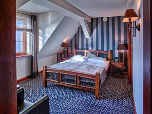 a bedroom with a bed in a room with a staircase at Hotel Tumski in Płock +42 photos