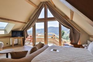 a bedroom with a bed and a large window at Domaine Le H in Munster