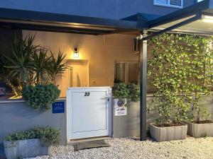 a white appliance sitting outside of a house with plants at Studio Mare in Zadar