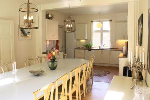 a kitchen with a table with a vase of flowers on it at The Lodge in Borre