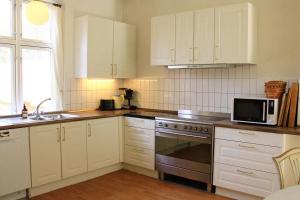 a kitchen with white cabinets and a stove top oven at The Lodge in Borre