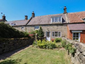 an old stone house with a stone wall at 4 Lilac Cottages in Whitby