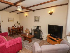 a living room with a couch and a tv at 4 Lilac Cottages in Whitby