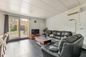 a living room with a leather couch and a tv at jutta in Mechelen