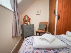 a small bedroom with a bed and a chair at 4 Lilac Cottages in Whitby